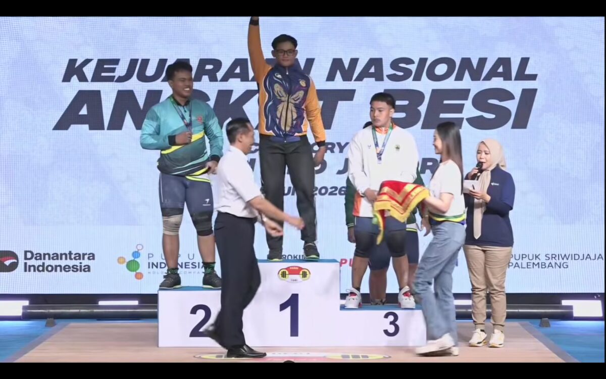 BERPRESTASI - Muhammad Nabil saat naik podium isai memastikan medali emas di nomor snatch. (Foto: Tommy Bahlevi)