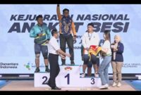 BERPRESTASI - Muhammad Nabil saat naik podium isai memastikan medali emas di nomor snatch. (Foto: Tommy Bahlevi)