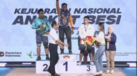 BERPRESTASI - Muhammad Nabil saat naik podium isai memastikan medali emas di nomor snatch. (Foto: Tommy Bahlevi)