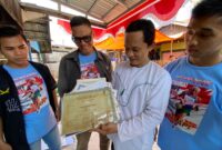 SOSOK - Salah satu anak Muhammad Arsyad atau Kai Api saat memperlihatkan piagam penghargaan Kai Api semasa menjadi atlet. (Foto: MGS)